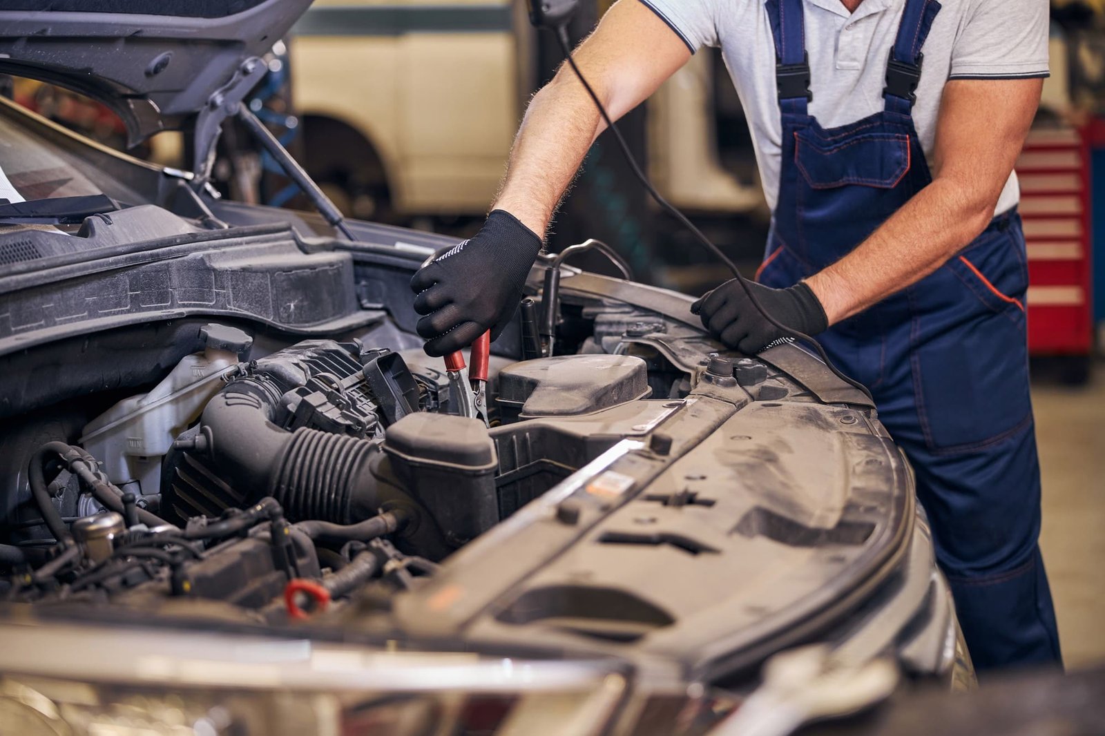 Mechaniker prüft die Batterie im Motorraum